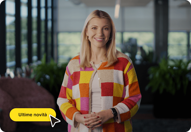 Immagine di una persona in piedi che sorride, con un'interfaccia utente astratta mobile del cursore di un mouse e di un pulsante. L'immagine mostra come gli utenti possono scoprire le nuove funzionalità avanzate di Mailchimp.